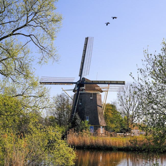 Scenic view of a traditional windmill in Amsterdam captured on a bright spring day.